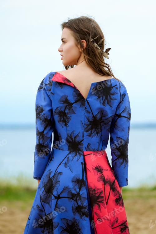 Preview: Back view of a girl standing on riverside and looking to left