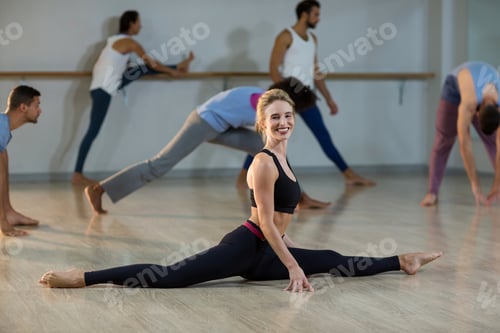Preview: Portrait Of Woman Performing Stretching Exercise In Fitness Studio