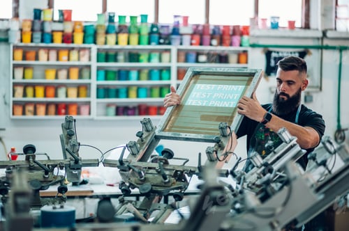 Preview: Male worker preparing screen printing film in a workshop