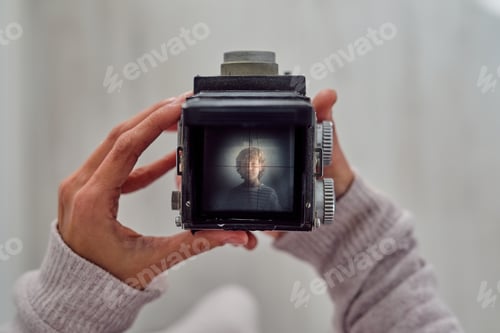 Preview: Crop photographer with photo of boy on retro camera display