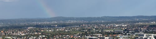 Preview: Banner 4x1 with a rainbow in the cloudy sky over the city after the rain