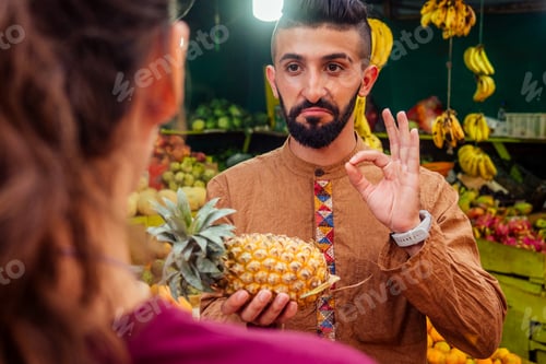 Preview: arabian man offering a pineapple on the street in goa
