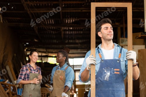 Preview: Portrait of carpenter male worker standing in front of colleague in workshop,