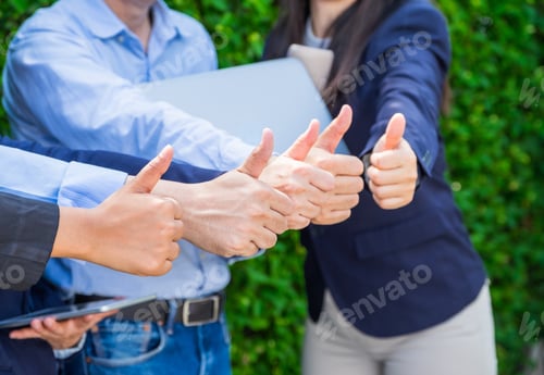 Preview: Close up at Group of businessman and woman thumbs up in front of office