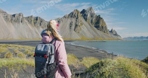 Preview: Morning scene of female traveler exploring Stokksnes cape with Vestrahorn in background Sunny summer