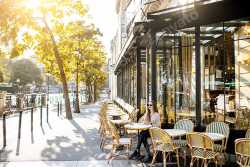 Preview: Woman sitting outdoors at the french cafe