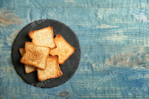 Preview: Slate plate with toasted bread on wooden background, top view
