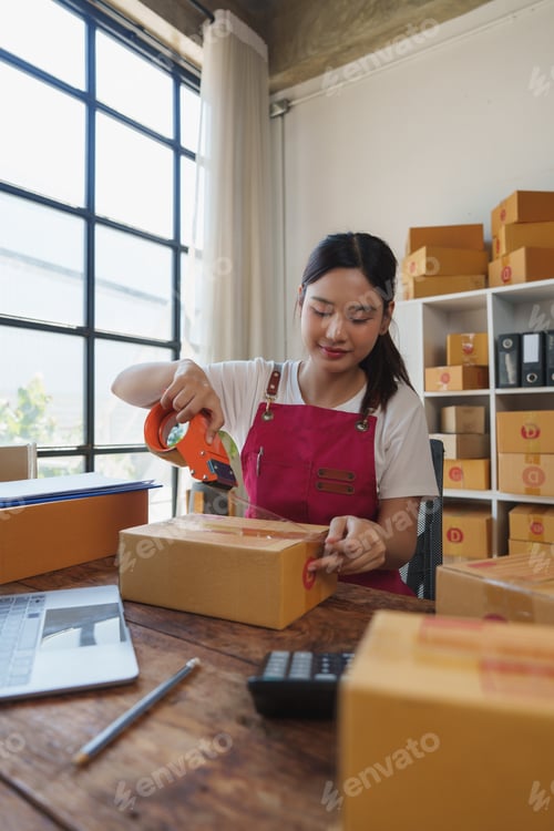 Preview: Young woman packing boxes for small business e commerce orders