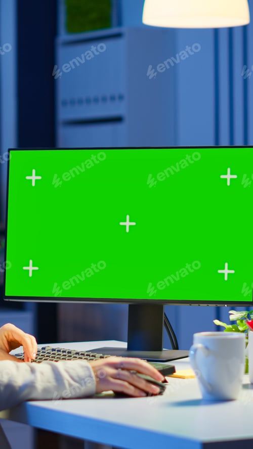 Preview: Woman looking at computer with chroma key during night time