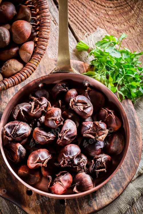 Preview: Hot chestnuts with parsley on old wooden table