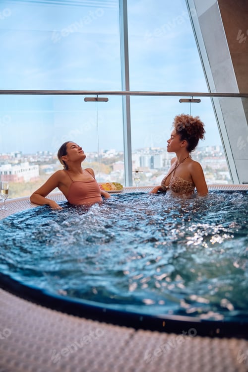 Preview: Young women relaxing in whirlpool at heath spa.