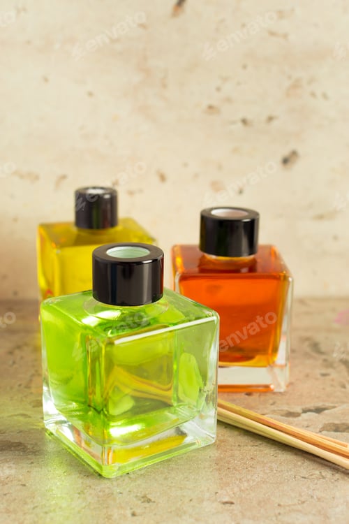 Preview: Colorful glass bottles of nail polish on a stone surface with wooden sticks nearby