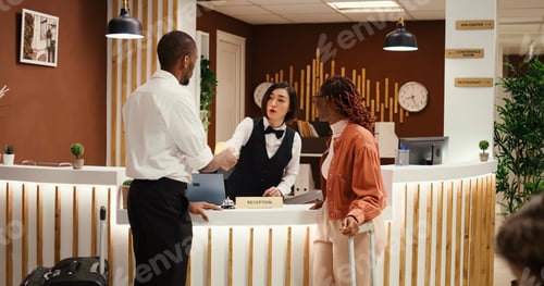 Preview: Receptionist offering room key to guests