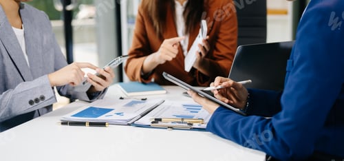 Preview: Business people and lawyers discussing contract papers sitting at the table