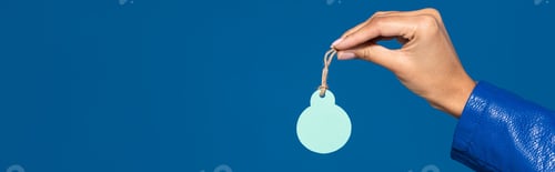 Preview: cropped view of african american woman holding blank label isolated on blue, panoramic shot