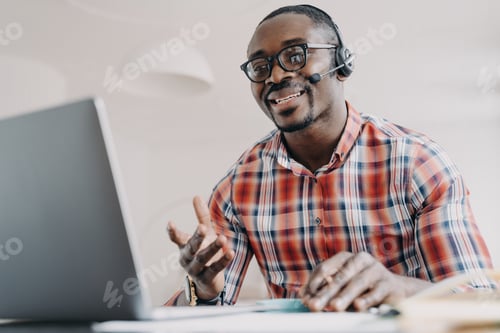 Preview: Friendly manager of client support service. African american man in headset receives calls.