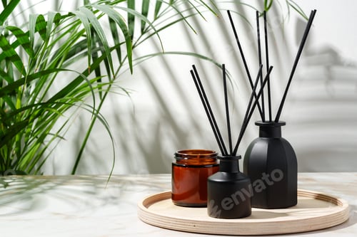 Preview: Black Reed Diffuser, Amber Candle, and Wooden Tray on White Surface