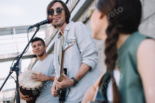 Preview: Multiracial young happy people performing and singing on street