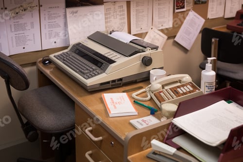 Preview: Old fashioned enclosed work office cubical with timber desk, telephone, papers, typewritter
