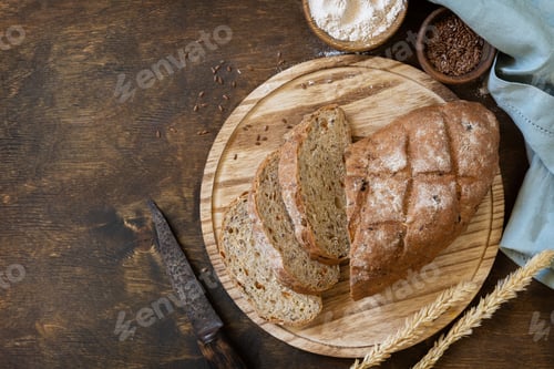 Preview: Bread from whole wheat grains, wheat bran, seeds, bio-ingredients over rustic table background.