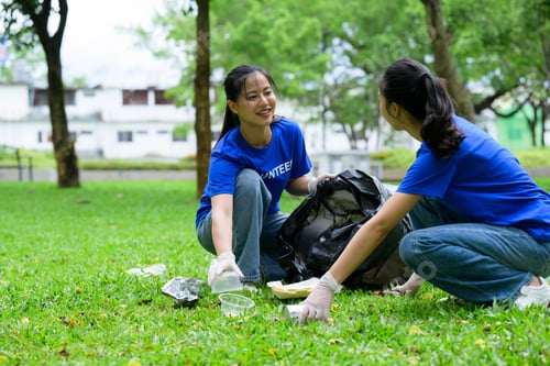 Preview: Volunteers collecting trash in park wearing gloves and blue shirts