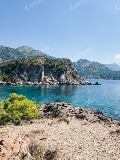 Preview: Top view Montenegro Sutomore stones beach blue turquoise Adriatic sea water mountains on sunset.