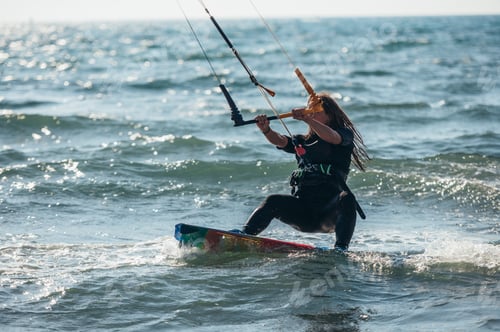 Vorschau: Frau beim Kitesurfen auf den Meeresgewässern