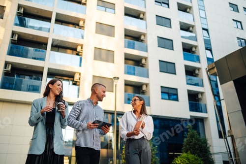 Preview: Real estate agents discussing business strategy holding digital tablet outside