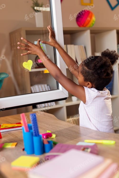 Preview: Little girl placing sticky notes on window