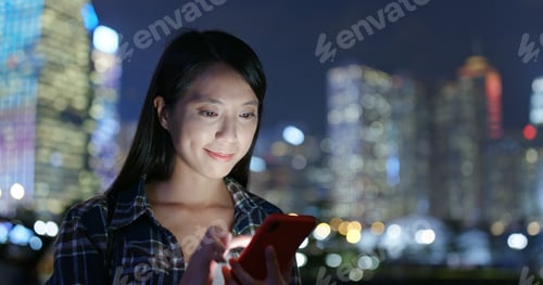 Preview: Woman use of mobile phone online in city at night