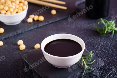 Preview: Soy sauce in a bowl and soy beans on the table.