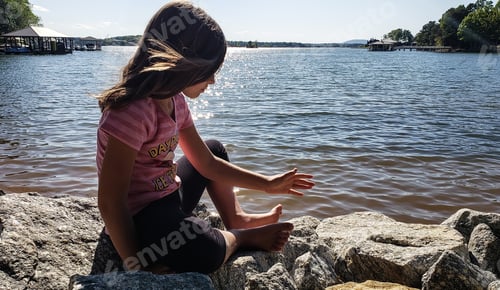 Preview: Gen z kid at the lake sitting on the rocks thinking in psychology.