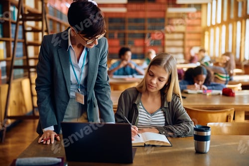 Preview: Female professor assisting high school student during a class in the classroom.