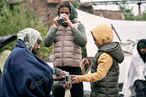Preview: Young man pouring water into mug of his daughter