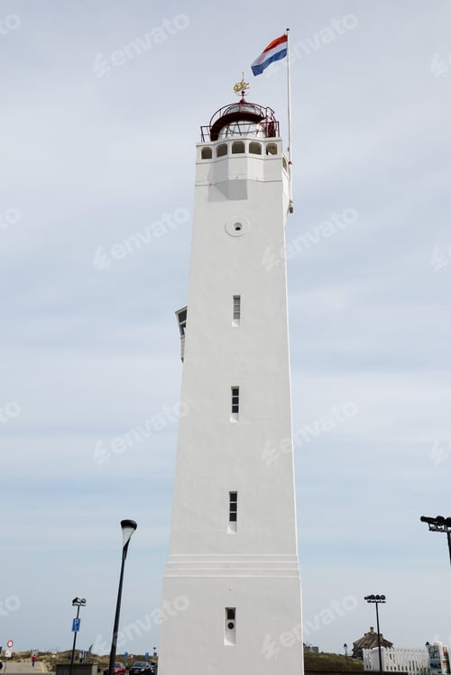 Preview: Building of lighthouse on shores of North Sea in Zandvoort in Netherlands with national flag at top