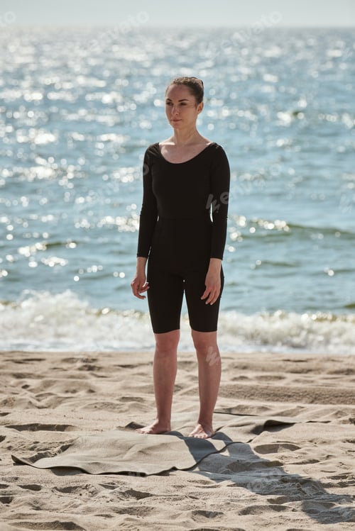 Preview: Young woman practicing yoga on Baltic Sea beach during sunny day