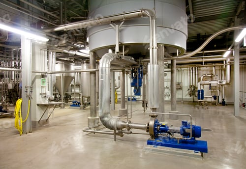Preview: Interior of brewery, large steel storage tanks for brewing beer with metal pipes and valves.