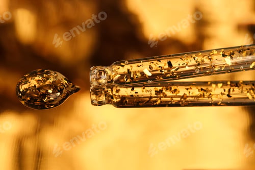 Preview: 24 k gold facial serum in a pipette on a gold background.