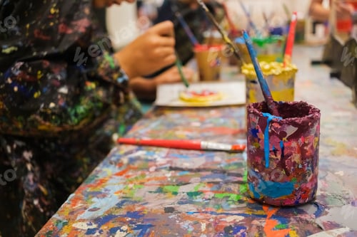 Preview: Children enjoy painting in art class, with dirty hands and smocks full of paint.