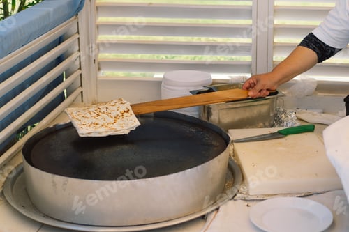 Preview: Woman Preparing Traditional Flatbread in Outdoor Market During Daytime