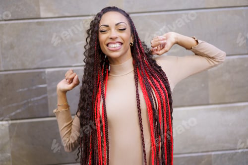 Preview: A Joyful and Cheerful Young Woman with Beautifully Braided Hair Posing Happily Outdoors