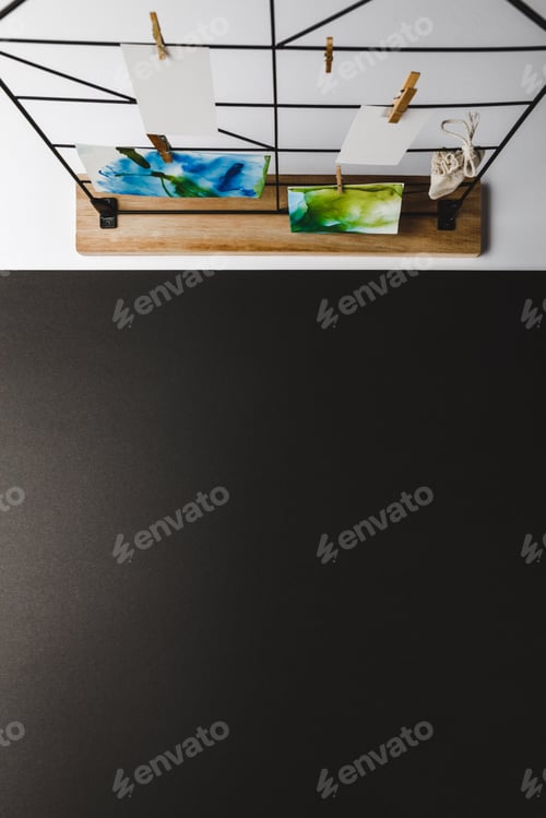 Preview: top view of beautiful abstract paintings and blank cards hanging on clothespins, black background