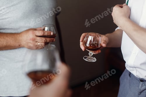 Preview: stylish handsome groom with groomsman hugging and holding whiskey in glass