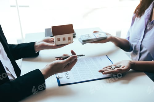 Preview: Hand of real estate agent passes the key to new homeowners in office with buyer house concept.