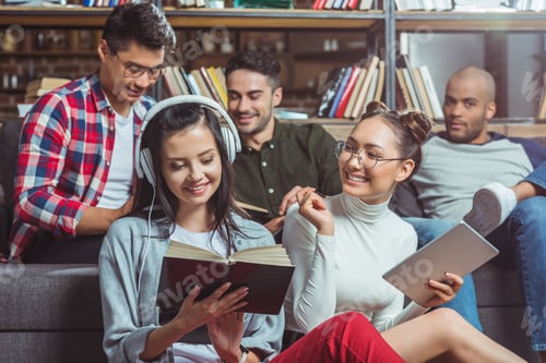 Preview: smiling young multiethnic students studying together indoors