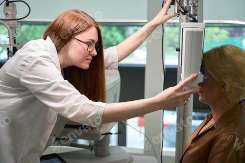 Preview: Red-haired doctor uses a dioptrimeter in her work