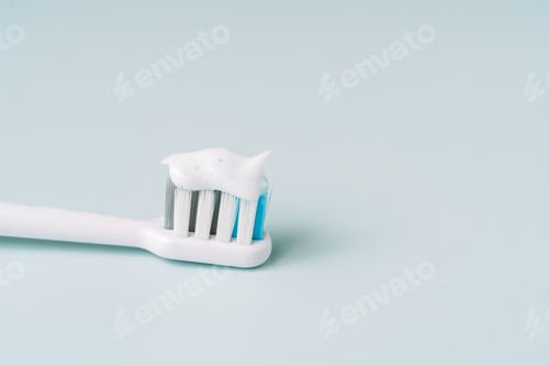Preview: Toothbrush with toothpaste on blue background