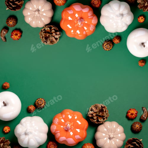 Preview: Autumn border with ceramic pumpkins, pine cones and autumn decor on dark green background