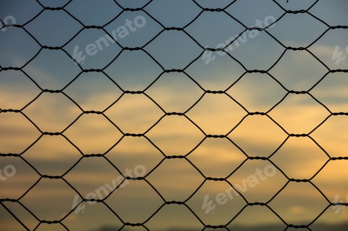 Preview: Metal fence against of evening cloudy sky