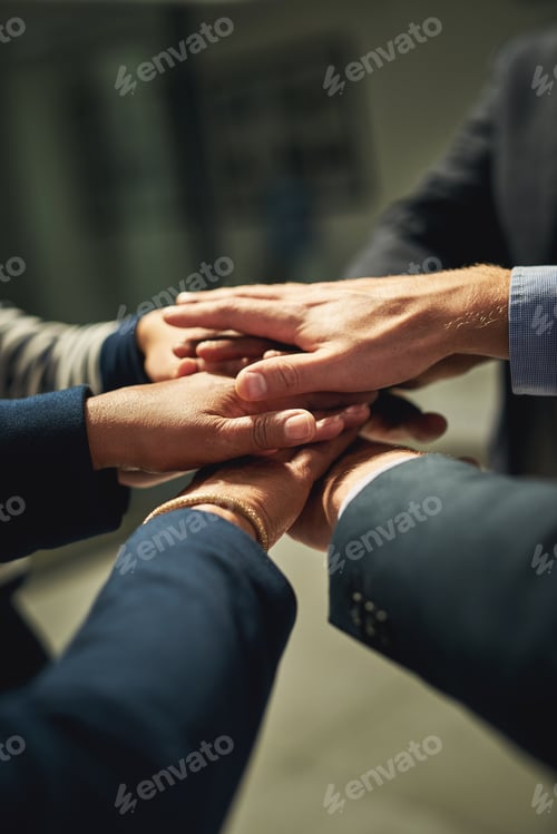Preview: Closeup shot of a group of unrecognizable businesspeople joining their hands together in a huddle